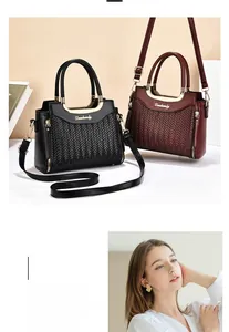 Détail de la texture tressée et du logo doré sur les sacs noirs et bordeaux