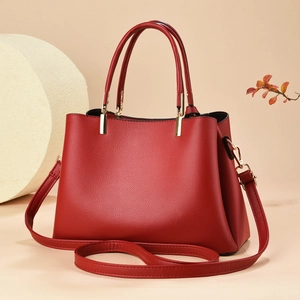 Elegant red pebbled leather handbag with gold hardware and adjustable crossbody strap