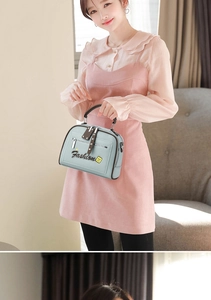 Detail of light blue faux leather handbag with brown top handle and floral embroidery