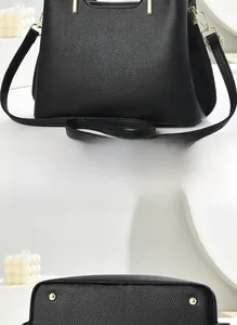 Vue détaillée du dos et des clous de protection dorés du sac en cuir litchi noir