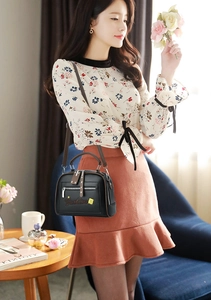 Close-up of black crossbody bag with rivet details and adjustable shoulder strap