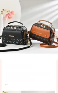 Close-up of black and brown monogrammed handbags with metal rings and front pockets