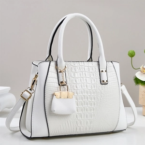 Elegant white crocodile embossed handbag with gold hardware and mini bag charm