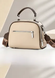 Detail view of the beige crossbody bag featuring a rear zipper pocket and wide jacquard strap