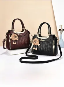 Close-up of retro woven texture and lion charm on black and burgundy handbags