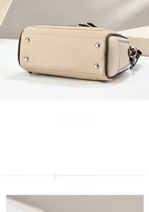 Detailed close-up of beige leather bag base with four silver metal protective feet