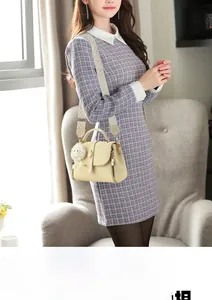Sac à main beige tissé avec large bandoulière à chevrons et pompon en peluche