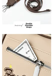 Detail view of khaki leather bag with double shoulder straps and cartoon embroidery