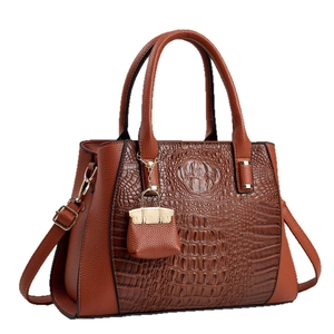 Brown crocodile embossed handbag with gold hardware and a mini bag charm pendant