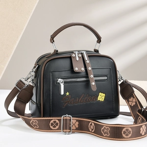 Chic black and brown crossbody bag with embroidered stars and wide geometric strap
