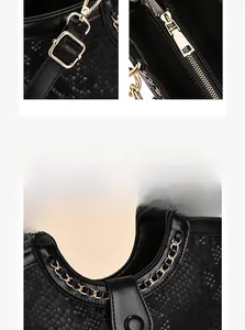 Detailed close-up of black crocodile pattern leather with shiny gold hardware and zippers