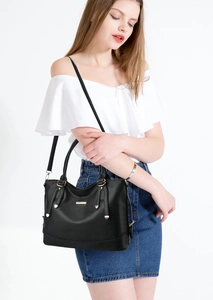 Close-up of black litchi grain leather handbag with gold hardware and logo detail