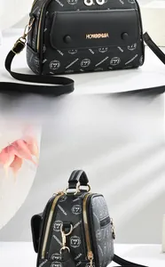 Detail of black printed crossbody bag with dual zippers and gold hardware accents
