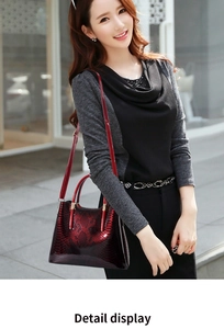 Detail view of burgundy snake-pattern handbag with metallic handles and adjustable strap