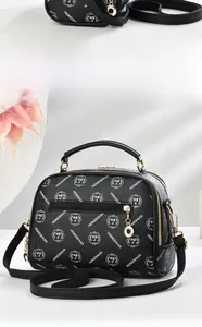 Side view of black lychee leather handbag with logo prints and golden metal hardware details