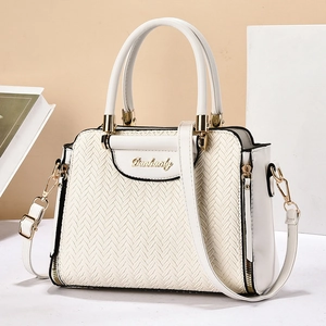Sac à main blanc à texture tressée avec détails dorés et bandoulière en studio photo