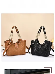 Close-up of snakeskin texture leather tote bags with gold chain handles and magnetic clasp