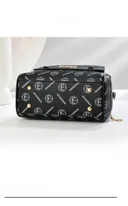 Detail of black pebbled leather bag bottom with four protective gold metal studs
