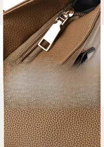 Detail of golden metal zipper and textured brown PU leather on large tote bag
