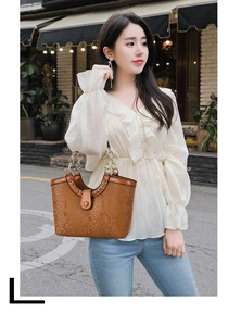 Outdoor shot of a brown snakeskin texture tote bag with gold chain strap detail