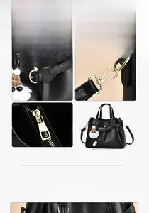 Detail view of black pebbled leather handbag with bow charm and golden metal hardware