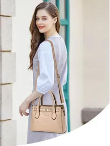Détail du sac beige à texture crocodile avec fermoir doré et bandoulière réglable