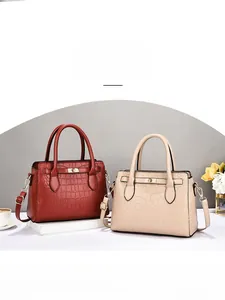 Détail de sacs à main vintage en cuir crocodile bordeaux et beige avec fermoir doré