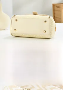 Détails du sac à main beige tissé avec pieds en métal doré et bandoulière tressée