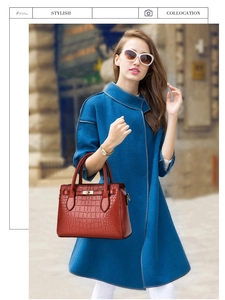Détail d'un sac à main rouge texture crocodile avec boucle métal et poignée haute