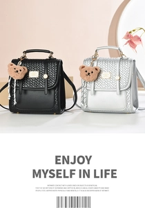Detail view of mini backpacks in black and silver with woven texture and plush bear charm