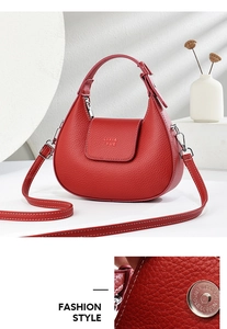 Détail du sac demi-lune en cuir rouge avec coutures blanches et boucle argentée polie