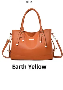 Detail view of tan faux leather handbag with golden metal trim and fine stitching