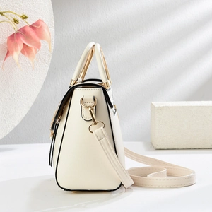 Petit sac bandoulière beige avec détails dorés et pendentif perle élégant