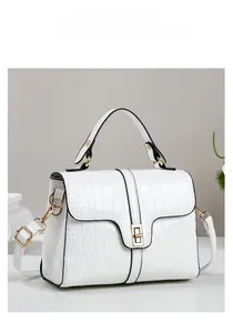 Détail d'un sac à main blanc motif crocodile avec fermoir doré et texture en cuir