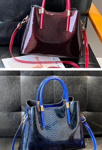 Close-up of snakeskin embossed glossy patent leather tote with gold hardware and handles