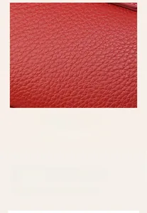 Vue macro détaillée du cuir rouge à motif litchi et des coutures sur le sac demi-lune
