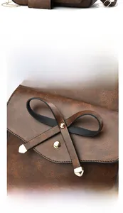 Détail du sac à dos en cuir PU marron avec décoration de nœud et rivets métalliques dorés