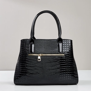 Close-up of black crocodile pattern leather texture and shiny golden zipper details