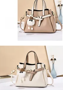 Detail of elegant two-tone leather handbags with bow charms and detachable straps