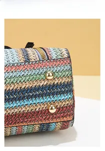 Detailed close-up of the multi-color woven handbag base with protective gold metal studs