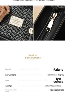 Detailed view of black woven fabric bag with gold metal logo and plush bear charm charm