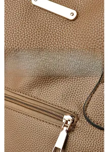 Detail of brown litchi pattern leather and gold metal logo plaque with high-quality zipper
