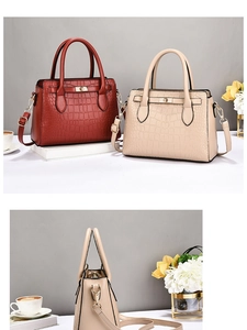 Détail de sacs à main en cuir croco avec fermoirs dorés rotatifs et doubles poignées