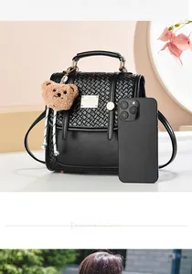Detail of black woven texture bag with gold hardware showing capacity for daily essentials