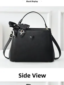 Side view of black matte leather bucket bag with heart detail and silk scarf handle