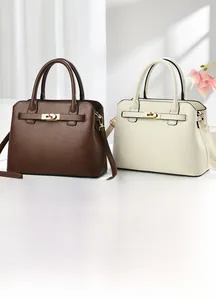 Close-up of minimalist leather handbags with metal locks in brown and off-white