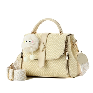 Sac à main macaron beige à texture tressée en V avec pendentif peluche sur fond blanc