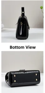 Détail du fond de sac en cuir verni noir avec pieds de protection en métal doré brillant