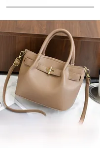 Detail of caramel lychee grain leather tote with gold metal buckle and dual strap