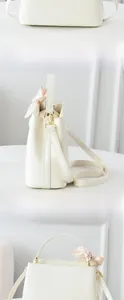 Detailed views of the side and back of a white PU leather bucket bag with a floral scarf handle